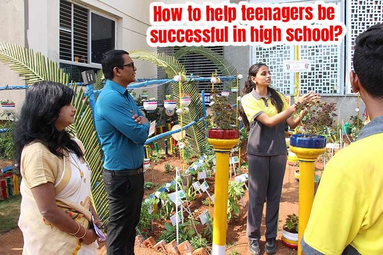 A group of teachers and teenagers standing in a garden