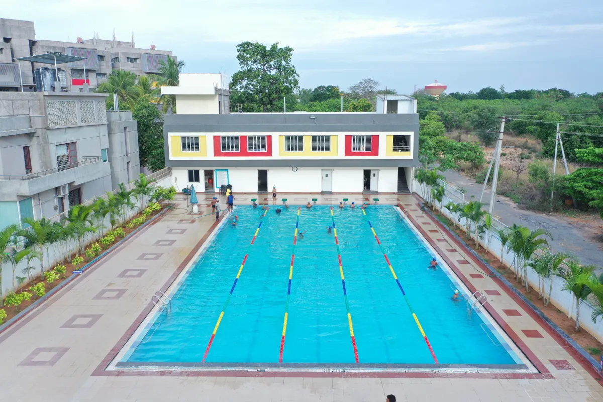 DPS, Warangal students practicing swimming in large pool under expert's guidance