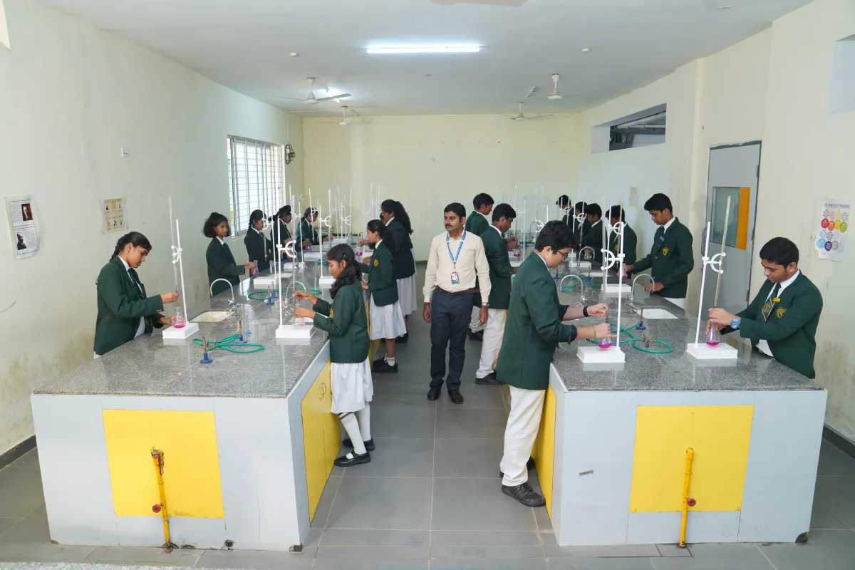 Students experimenting in the chemistry lab under teacher's guidance at DPS, Warangal