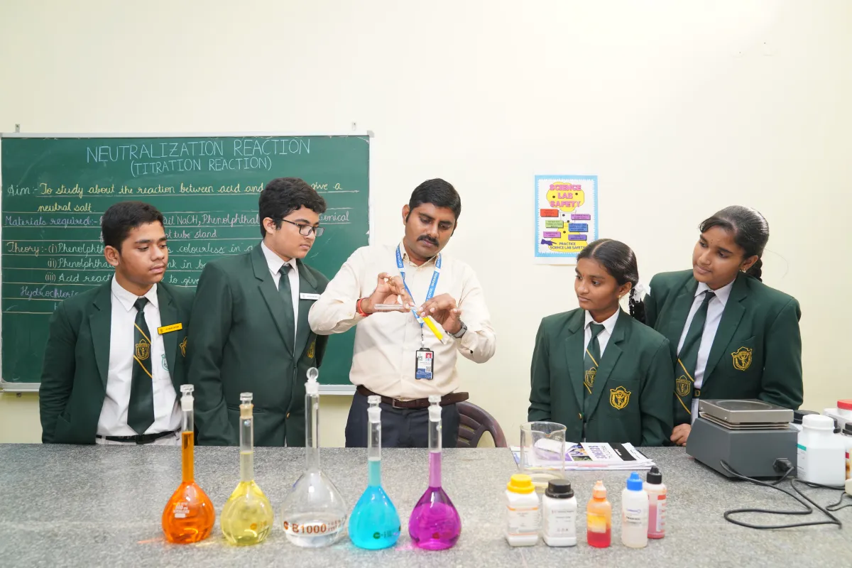 Teachers demonstrating chemical experiments to the students in the chemistry laboratory