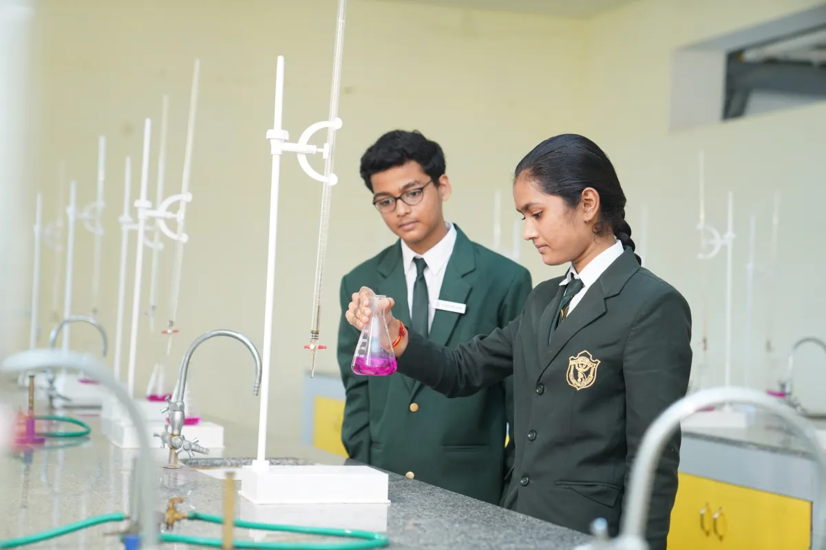 Students performing experiments in the chemistry laboratory of DPS Warangal school