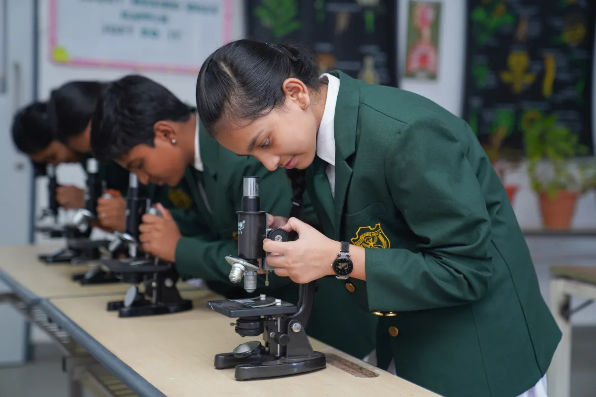 Children learning and observing through a microscope at the Biology - lab