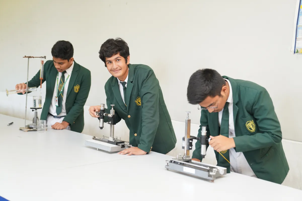 Students in white-green uniforms performing experiments in the lab.
