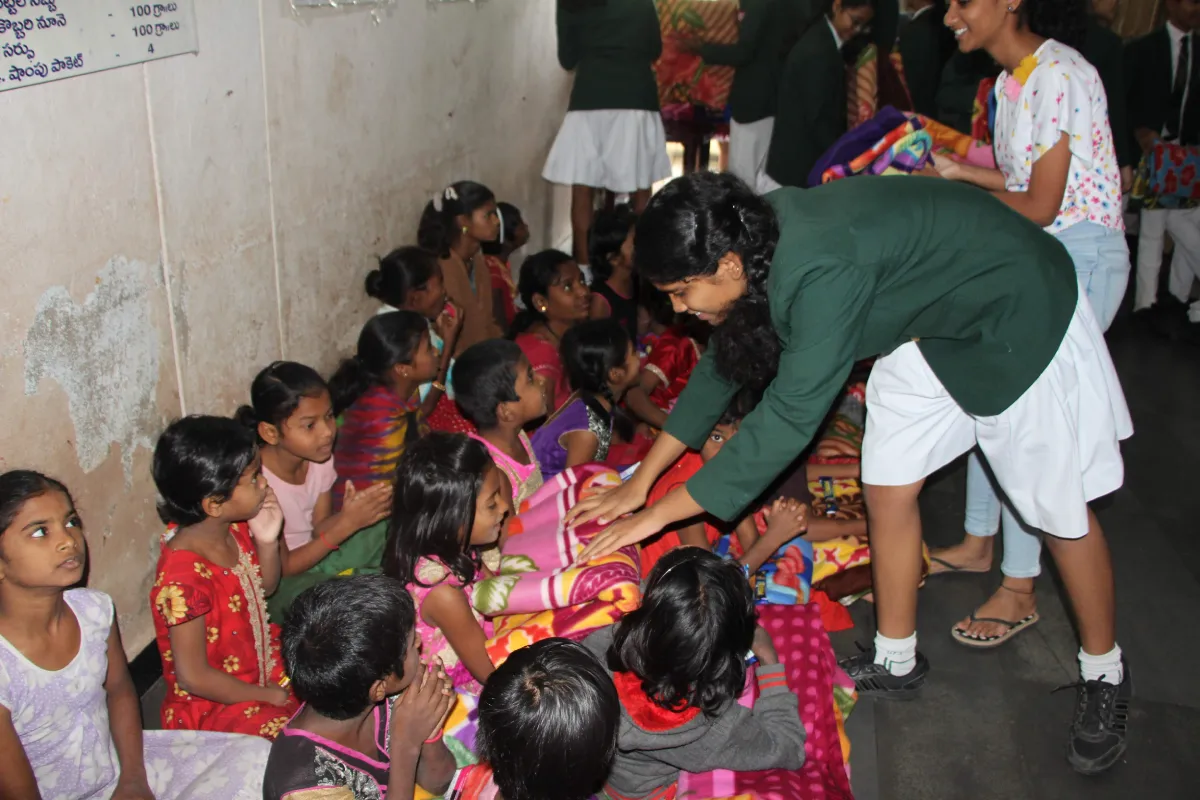 Students of DPS Warangal donating blankets to poor children to help them.