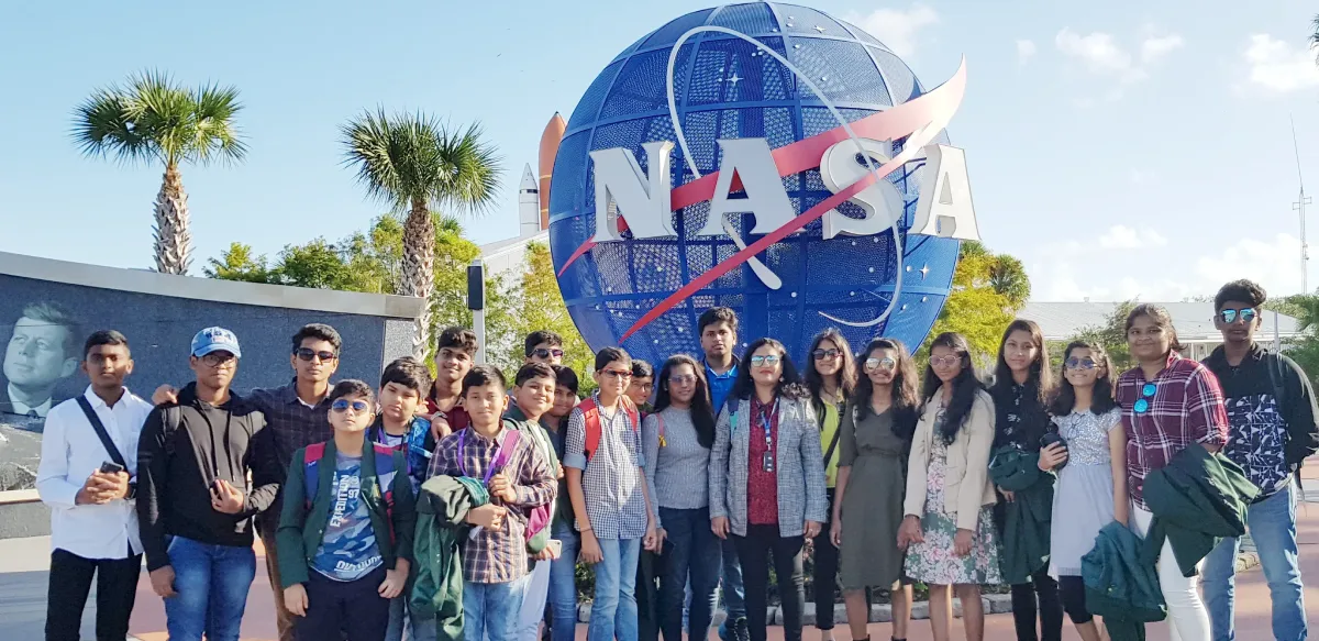 DPS Warangal students and a teacher standing ahead of NASA globe.
