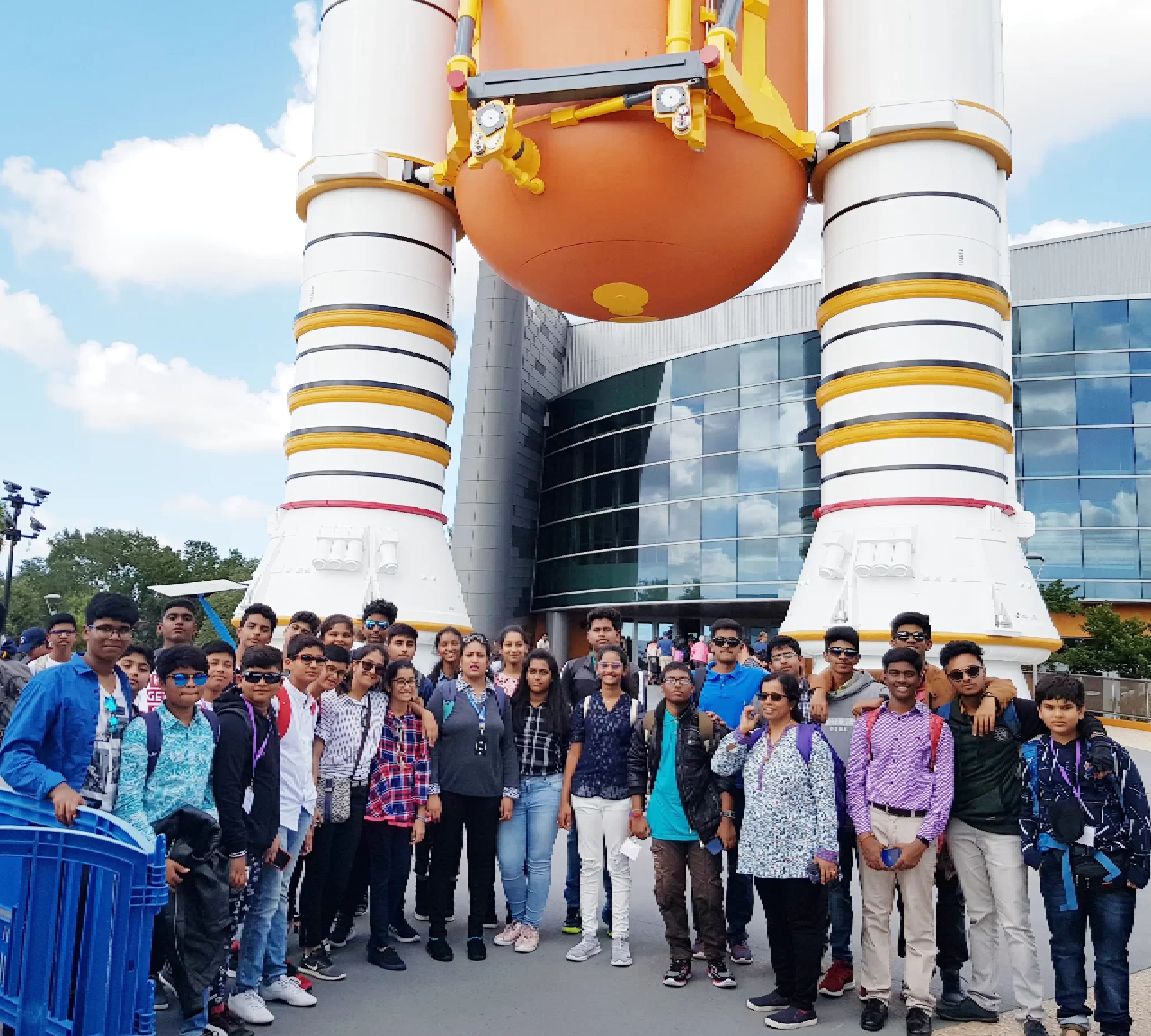 Students clicking picture outside the space centre in group during visit to NASA.