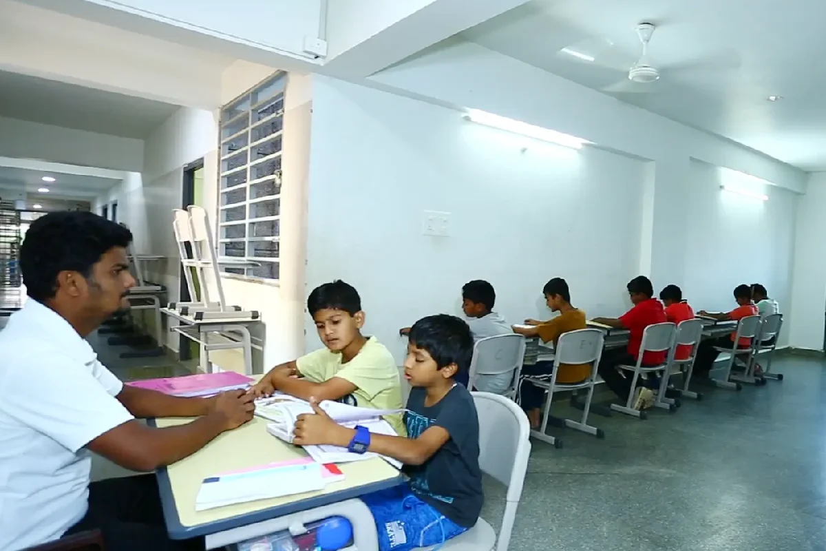 Students studying in a room with the school tutor.