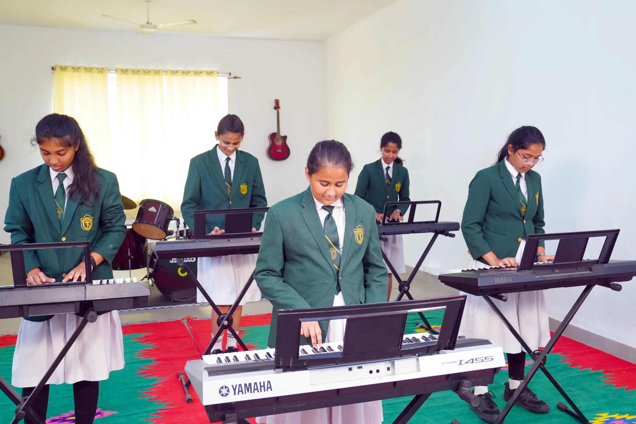 Girls in school uniform playing keyboard in the music hall of DPS, Warangal.