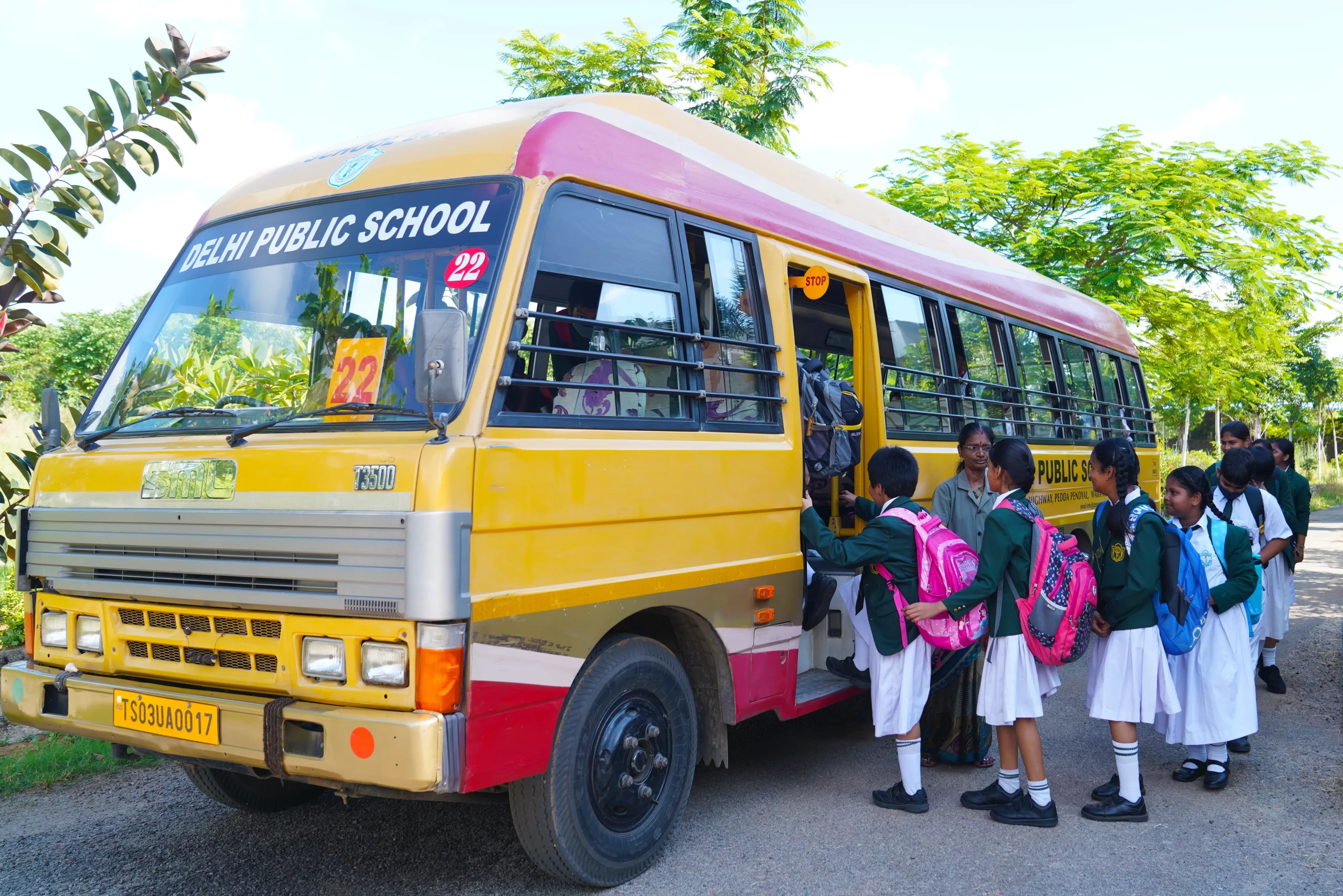 Students of DPS, Warangal entering the yellow coloured school bus in proper sequence.
