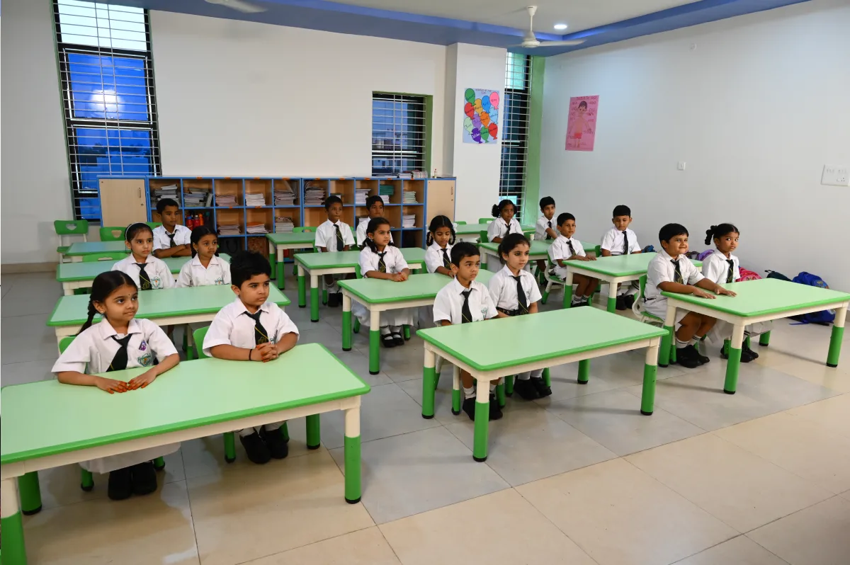 Students sitting in a disciplined manner in classroom of DPS, Hanamkonda, Warangal where tables are of green colour.