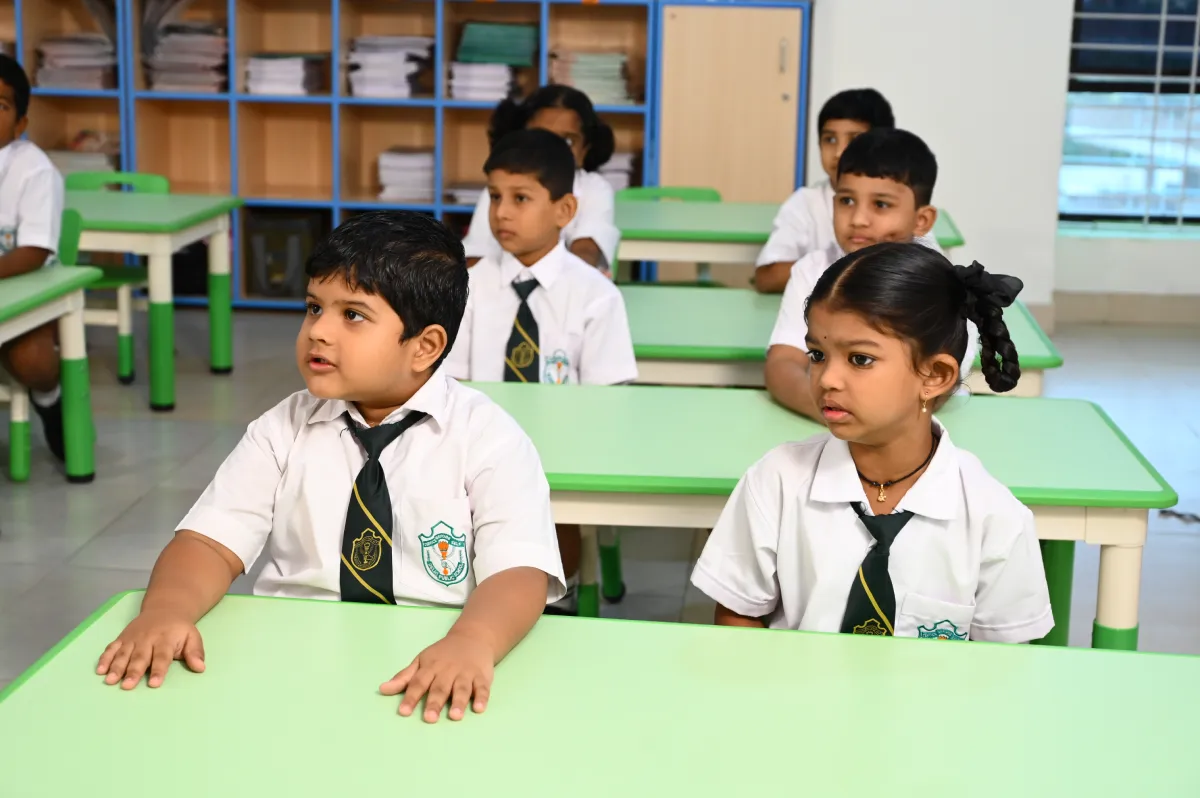 Students of primary class sitting in their classroom having green coloured tables at DPS, Hanamkonda.