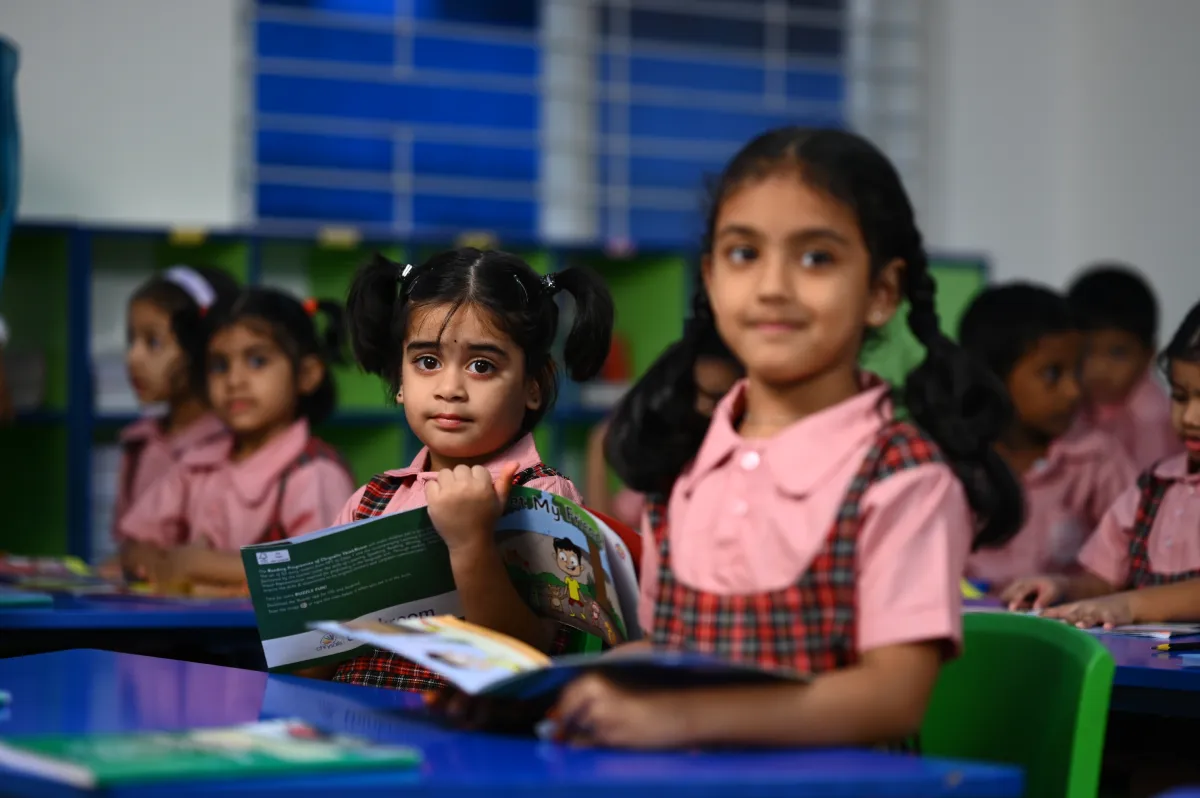Pre-primary class kids sitting in their classrooms in school uniforms with books in their hands at DPS, Hanamkonda, Warangal.