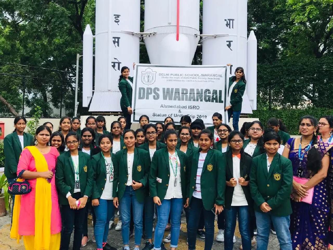 Students along with teacher clicking group picture in front of ISRO Space project