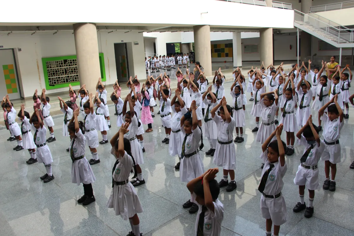 Students of DPS, Warangal in proper dress standing on assembly ground and praying with folded hands.