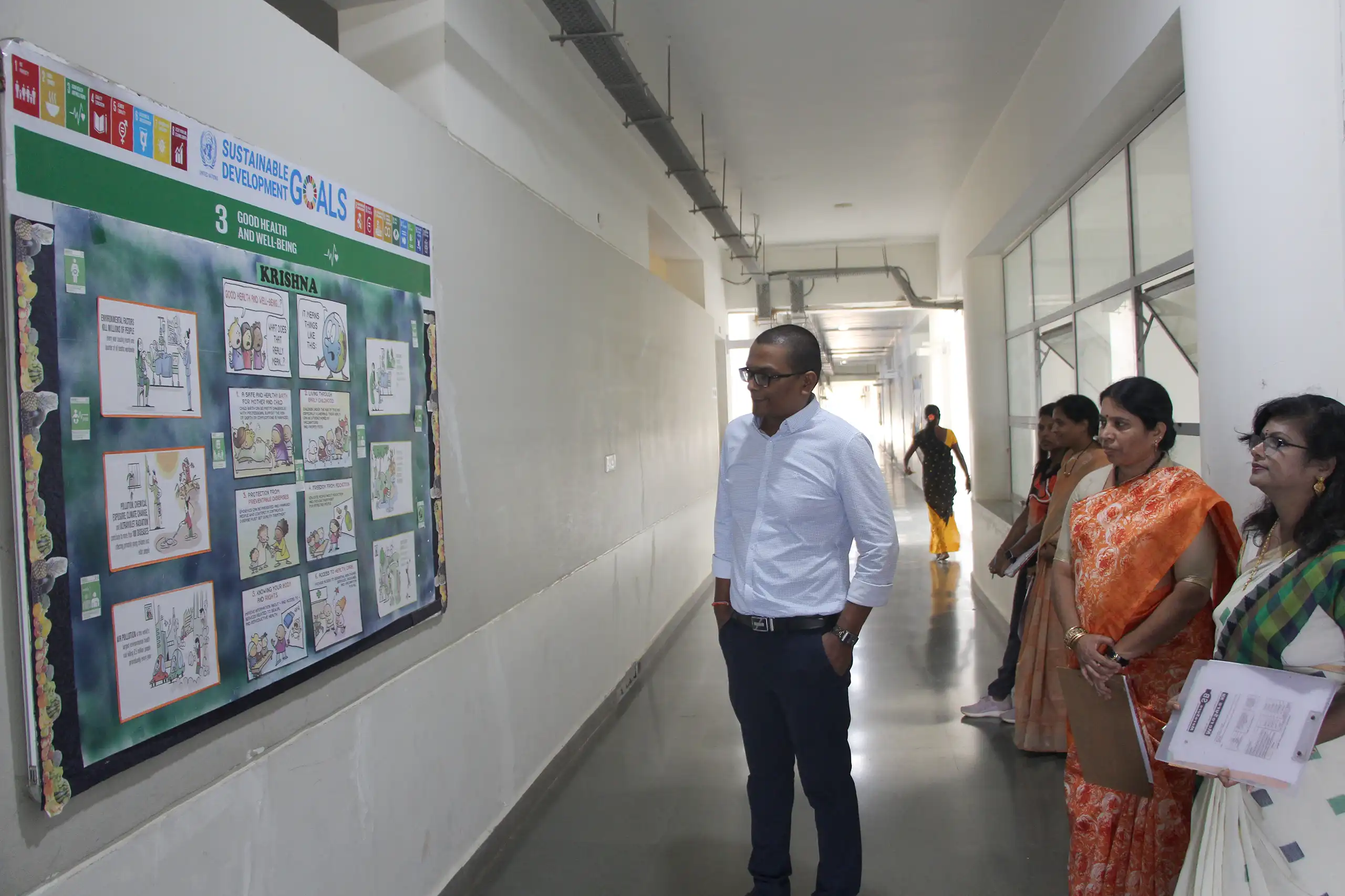 Teachers looking at the bulletin board which students have decorted during House-Wise Bulletin Board Competition.