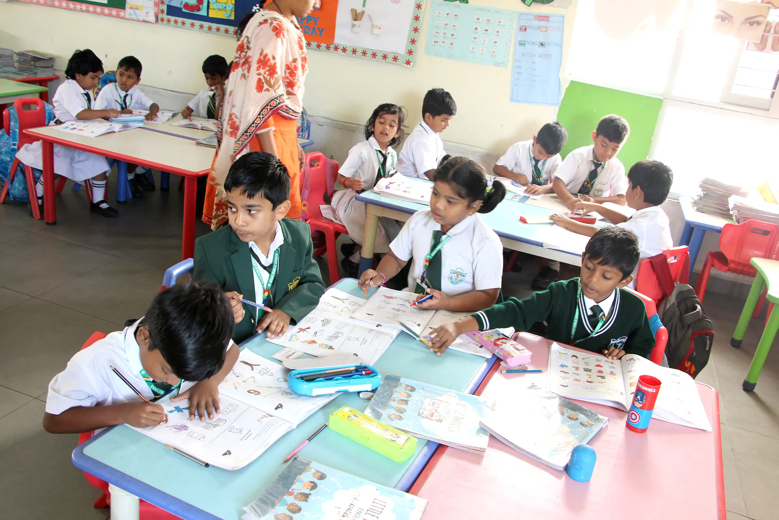 Students of DPS Warangal sitting in the class and completing their work under the guidance of teacher.