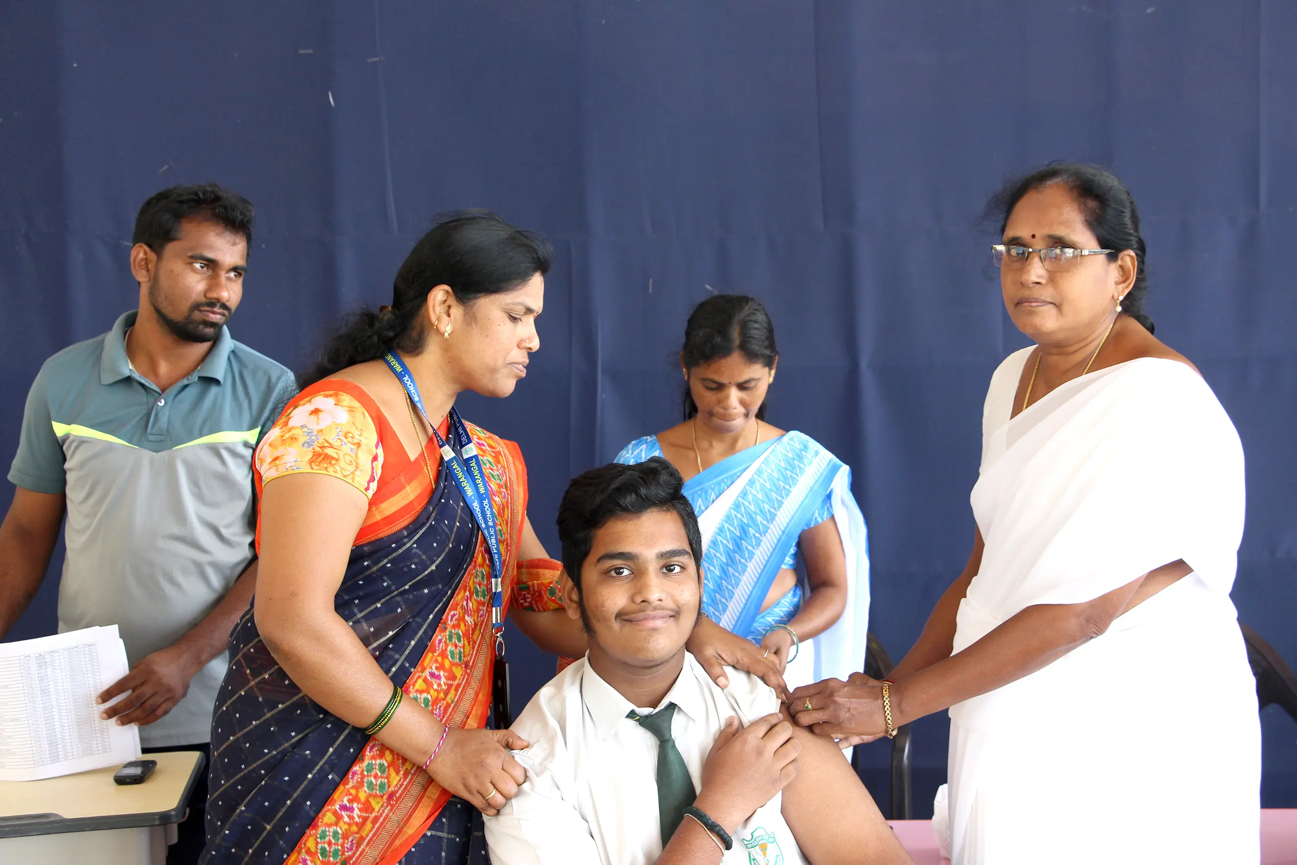 Student of DPS Warangal getting vaccinated during TD Vaccination drive in the presence of teachers and other students.