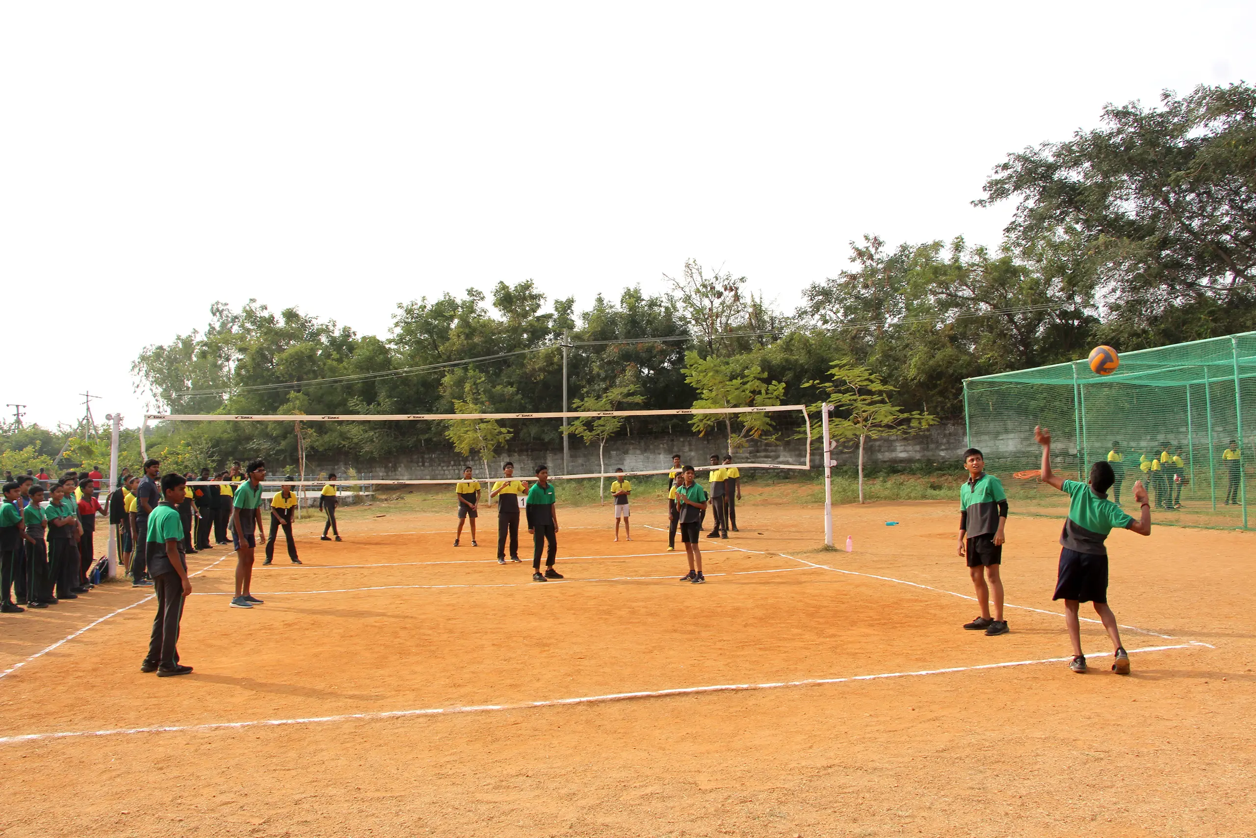 Students playing volleyball on the ground at DPS Warangal.