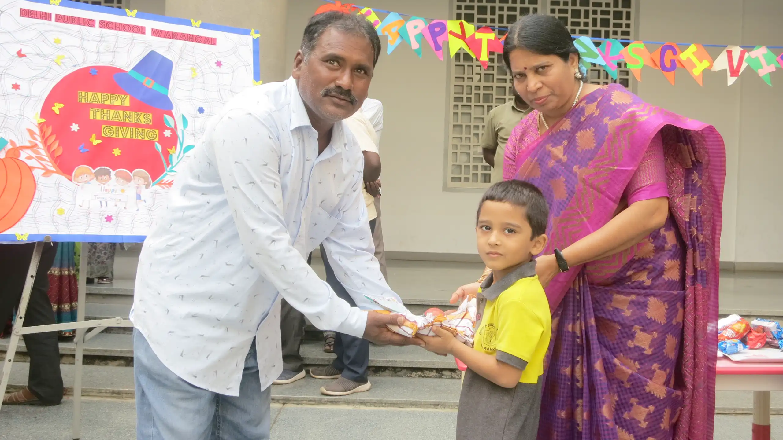 Students of DPS Warangal receiving prizes from teachers during thanks giving celebration.