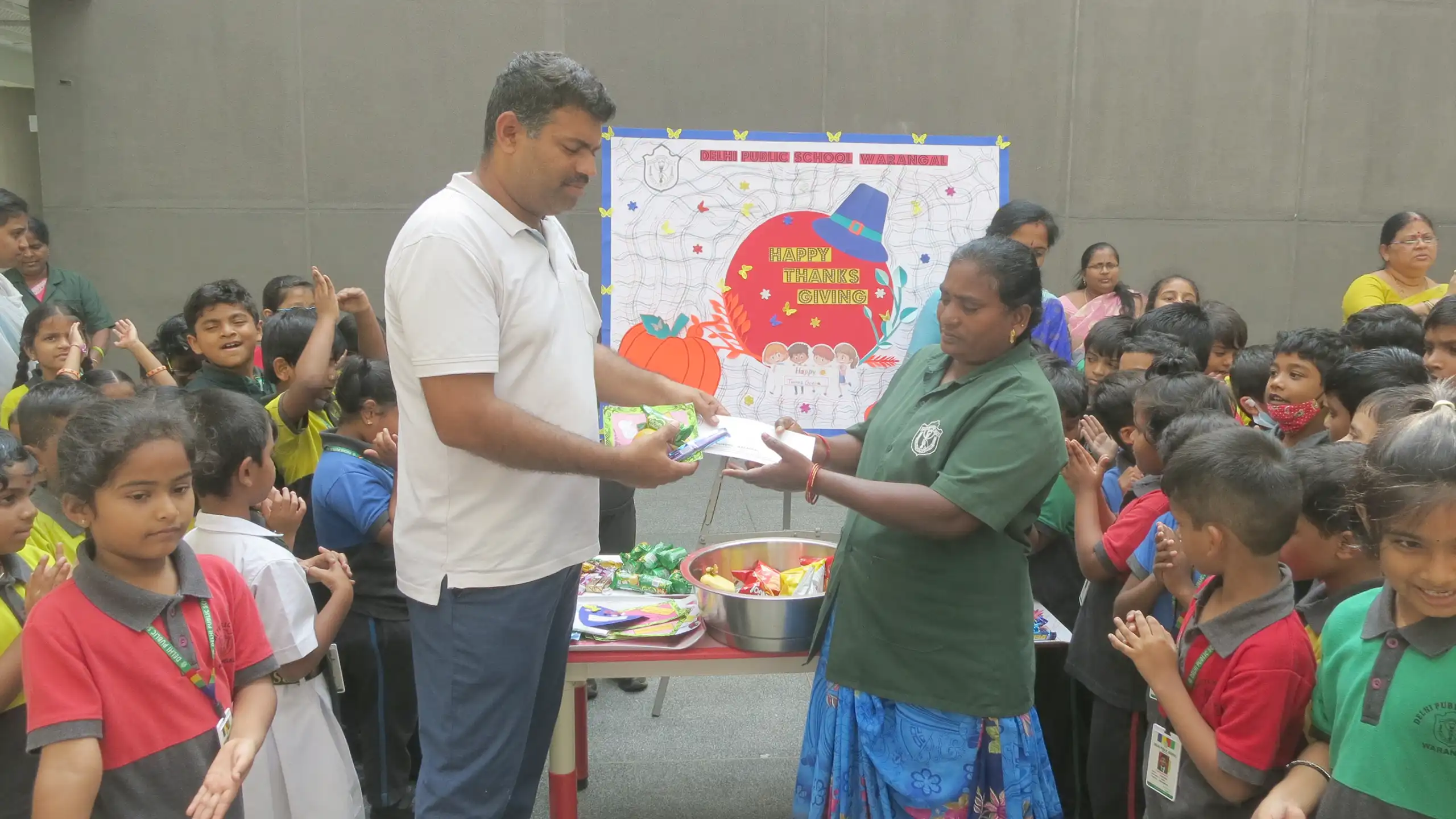 Staffs and helpers receiving gifts during thanksgiving celebration at DPS Warangal.