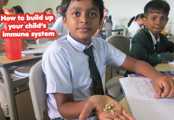 A young child holding a handful of small objects and Guide on boosting your child's immune system using the best school, DPS Warangal.