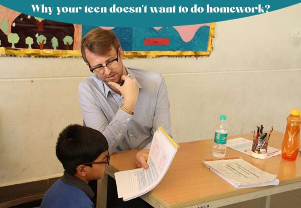 A person and children sitting at a table reviewing the homework