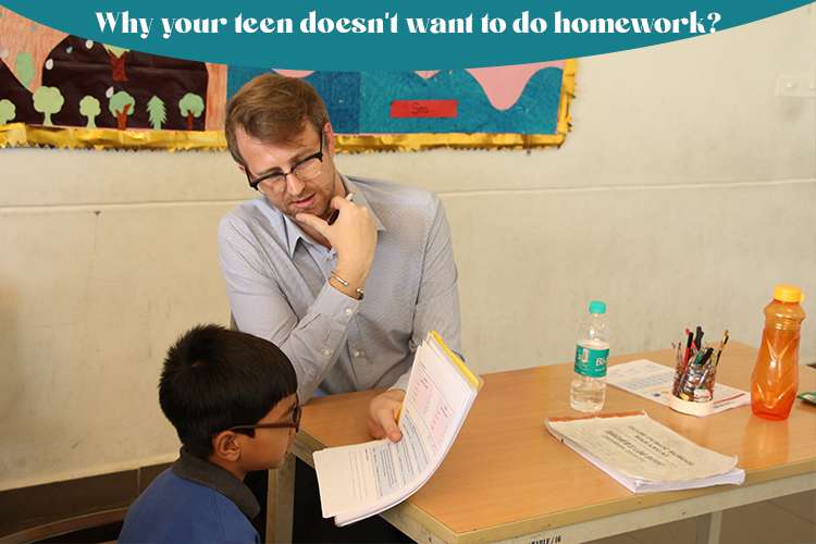 A person and children sitting at a table reviewing the homework