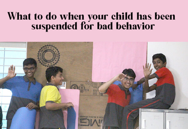 A group of boys waving with smiles from the classroom, indicating bad behavior of the kids