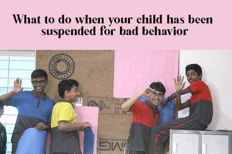 A group of boys waving with smiles from the classroom, indicating bad behavior of the kids