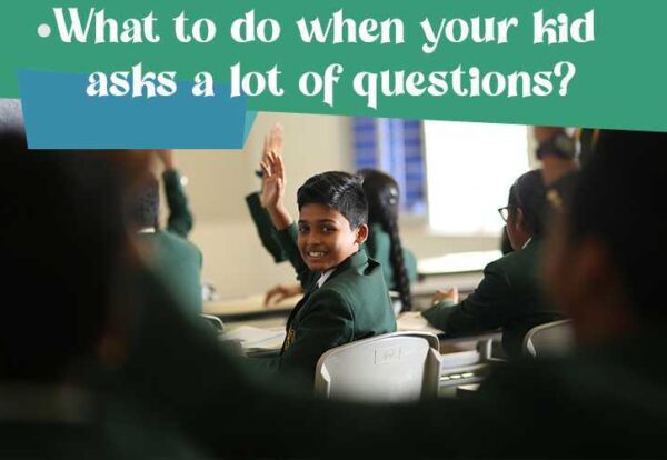 A child raising his hand in a classroom to ask questions