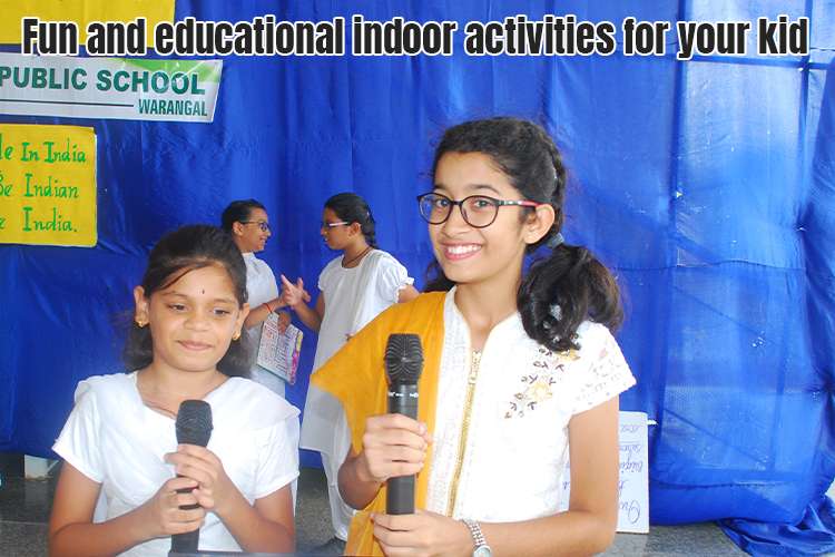 two young girls holding microphones in front of a blue backdrop telling about the importance of indoor games