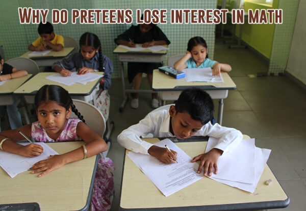 A group of children sitting at desks in a classroom doing math questions