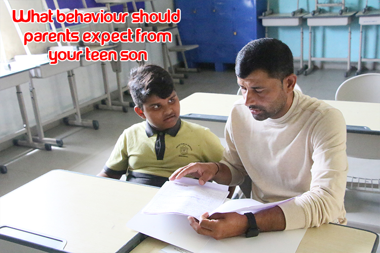 A person and child sitting at a desk taking a session on behaviour