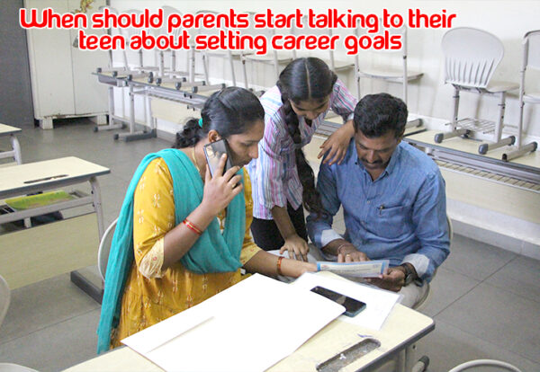 A parent and teen looking at a paper, discussing future career goals.