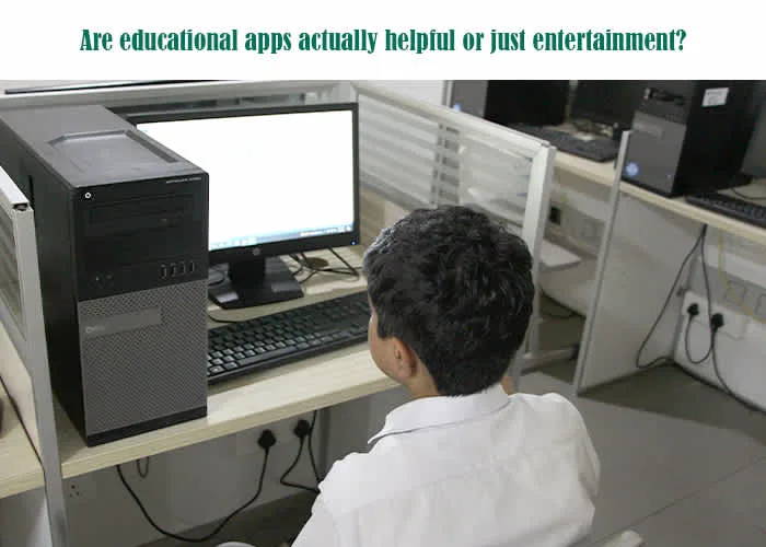 A child sitting at a computer in a classroom setting, illustrating the question of whether educational apps for children are genuinely helpful or simply a form of entertainment.