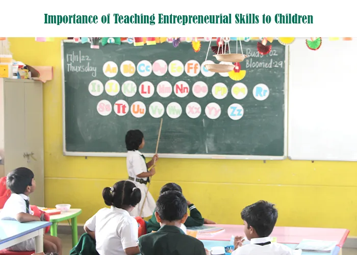 A classroom scene where a child stands at the blackboard, pointing to alphabet charts, illustrating how early classroom activities can support entrepreneurial thinking for children.