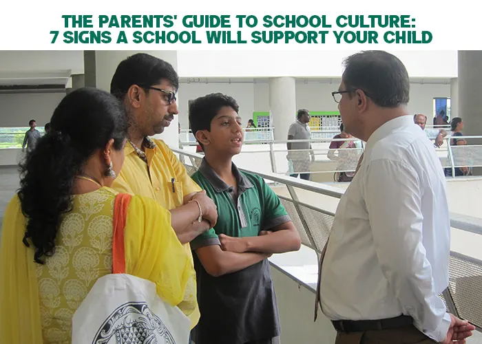 A student standing with his parents while speaking to a school staff member in a hallway, illustrating how supportive school culture involves open communication between families and educators.